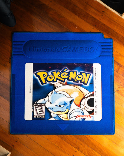 Pokemon Blue cartridge cut-out rug laid out on a floor