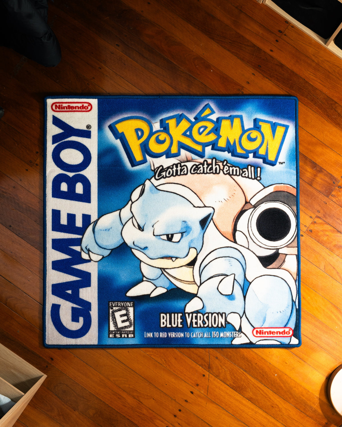 Pokemon Blue box art rug laid out on a floor