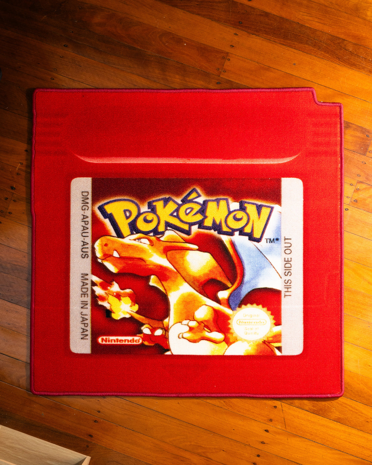 Pokemon Red cartridge cut-out rug laid out on a floor